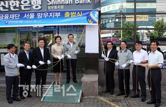 사진 좌측부터 첫번째 장훈기 미소금융중앙재단 기획관리본부장, 두번째 김종건 신용회복위원회 사무국장, 세번째 최종구 금융위원회 상임위원, 다섯번째 신한금융지주 라응찬 회장, 여섯번째, 문병권 서울시 중랑구청장, 일곱번째 신한미소금융재단 이백순 이사장, 아홉번째 유의준 우림시장 상점가 진흥조합 이사장이 현판식을 하고 있다.