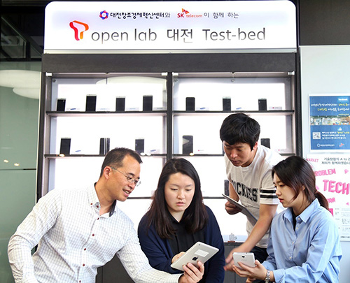 대전창조경제혁신센터내에 설치된 T오픈랩 테스트베드에서 대전센터 및 입주 벤처업체 직원들이 테스트용 단말기를 보며 실험결과를 논의하고 있다.