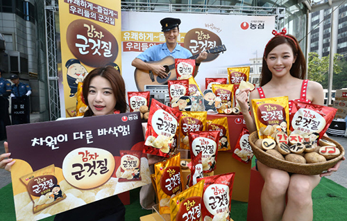 15일 서울 중구 청계광장에서 모델들이 농심이 출시한 감자스낵 ‘감자군것질’을 선보이고 있다.